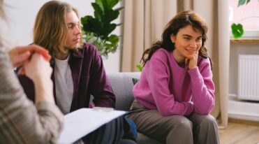 Couple engaging in a therapy session indoors with a mental health expert.